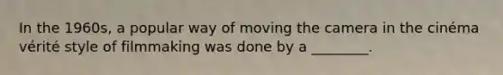 In the 1960s, a popular way of moving the camera in the cinéma vérité style of filmmaking was done by a ________.