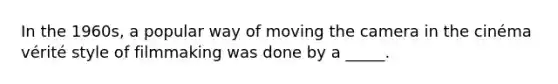 In the 1960s, a popular way of moving the camera in the cinéma vérité style of filmmaking was done by a _____.