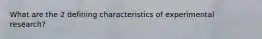 What are the 2 defining characteristics of experimental research?