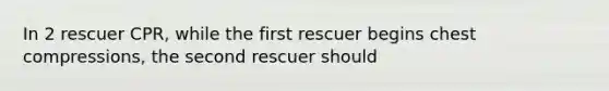 In 2 rescuer CPR, while the first rescuer begins chest compressions, the second rescuer should