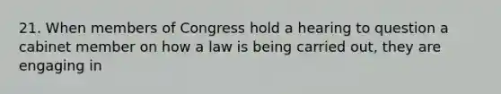 21. When members of Congress hold a hearing to question a cabinet member on how a law is being carried out, they are engaging in