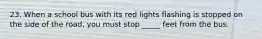 23. When a school bus with its red lights flashing is stopped on the side of the road, you must stop _____ feet from the bus.