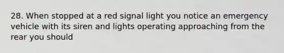 28. When stopped at a red signal light you notice an emergency vehicle with its siren and lights operating approaching from the rear you should