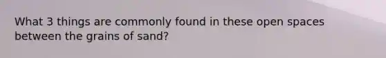 What 3 things are commonly found in these open spaces between the grains of sand?