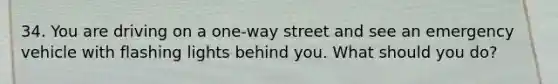 34. You are driving on a one-way street and see an emergency vehicle with flashing lights behind you. What should you do?