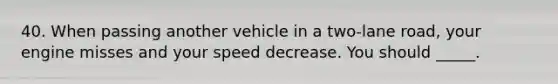 40. When passing another vehicle in a two-lane road, your engine misses and your speed decrease. You should _____.