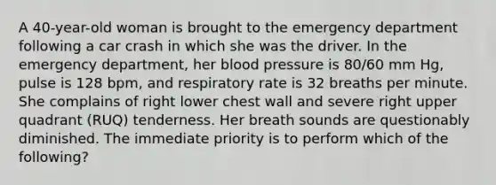 A 40-year-old woman is brought to the emergency department following a car crash in which she was the driver. In the emergency department, her blood pressure is 80/60 mm Hg, pulse is 128 bpm, and respiratory rate is 32 breaths per minute. She complains of right lower chest wall and severe right upper quadrant (RUQ) tenderness. Her breath sounds are questionably diminished. The immediate priority is to perform which of the following?