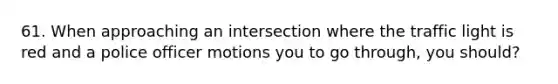 61. When approaching an intersection where the traffic light is red and a police officer motions you to go through, you should?