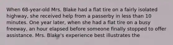 When 68-year-old Mrs. Blake had a flat tire on a fairly isolated highway, she received help from a passerby in <a href='https://www.questionai.com/knowledge/k7BtlYpAMX-less-than' class='anchor-knowledge'>less than</a> 10 minutes. One year later, when she had a flat tire on a busy freeway, an hour elapsed before someone finally stopped to offer assistance. Mrs. Blake's experience best illustrates the