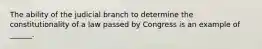 The ability of the judicial branch to determine the constitutionality of a law passed by Congress is an example of ______.