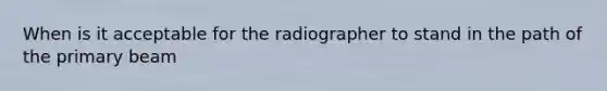 When is it acceptable for the radiographer to stand in the path of the primary beam