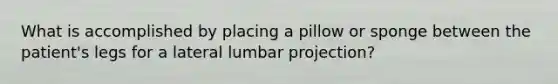 What is accomplished by placing a pillow or sponge between the patient's legs for a lateral lumbar projection?