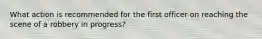 What action is recommended for the first officer on reaching the scene of a robbery in progress?