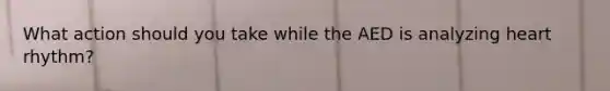 What action should you take while the AED is analyzing heart rhythm?