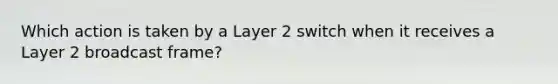 Which action is taken by a Layer 2 switch when it receives a Layer 2 broadcast frame?