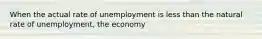 When the actual rate of unemployment is less than the natural rate of unemployment, the economy