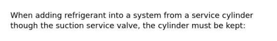 When adding refrigerant into a system from a service cylinder though the suction service valve, the cylinder must be kept: