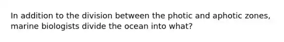 In addition to the division between the photic and aphotic zones, marine biologists divide the ocean into what?