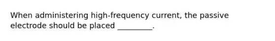 When administering high-frequency current, the passive electrode should be placed _________.