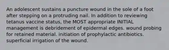 An adolescent sustains a puncture wound in the sole of a foot after stepping on a protruding nail. In addition to reviewing tetanus vaccine status, the MOST appropriate INITIAL management is debridement of epidermal edges. wound probing for retained material. initiation of prophylactic antibiotics. superficial irrigation of the wound.