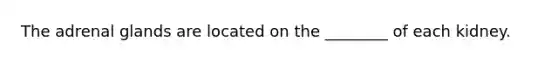 The adrenal glands are located on the ________ of each kidney.