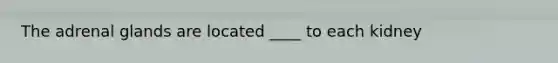 The adrenal glands are located ____ to each kidney