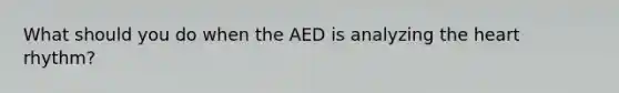 What should you do when the AED is analyzing the heart rhythm?