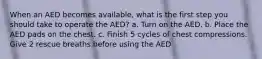 When an AED becomes available, what is the first step you should take to operate the AED? a. Turn on the AED. b. Place the AED pads on the chest. c. Finish 5 cycles of chest compressions. Give 2 rescue breaths before using the AED