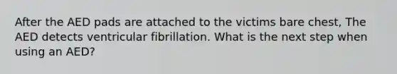 After the AED pads are attached to the victims bare chest, The AED detects ventricular fibrillation. What is the next step when using an AED?