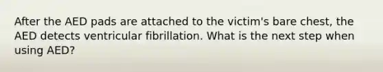 After the AED pads are attached to the victim's bare chest, the AED detects ventricular fibrillation. What is the next step when using AED?