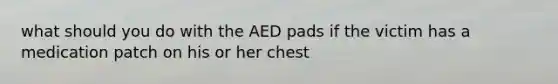 what should you do with the AED pads if the victim has a medication patch on his or her chest