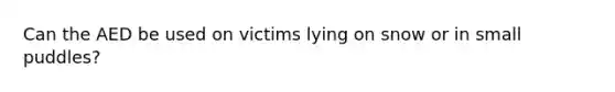 Can the AED be used on victims lying on snow or in small puddles?