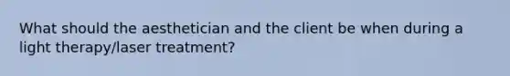 What should the aesthetician and the client be when during a light therapy/laser treatment?