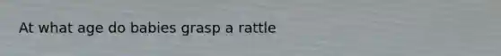 At what age do babies grasp a rattle