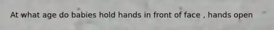 At what age do babies hold hands in front of face , hands open