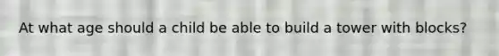 At what age should a child be able to build a tower with blocks?