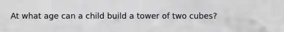 At what age can a child build a tower of two cubes?