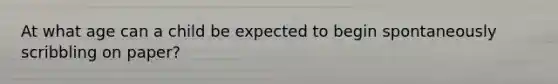 At what age can a child be expected to begin spontaneously scribbling on paper?