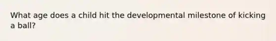 What age does a child hit the developmental milestone of kicking a ball?