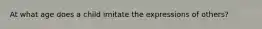 At what age does a child imitate the expressions of others?