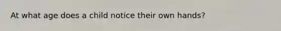 At what age does a child notice their own hands?