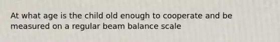 At what age is the child old enough to cooperate and be measured on a regular beam balance scale