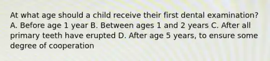 At what age should a child receive their first dental examination? A. Before age 1 year B. Between ages 1 and 2 years C. After all primary teeth have erupted D. After age 5 years, to ensure some degree of cooperation