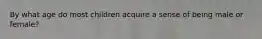 By what age do most children acquire a sense of being male or female?
