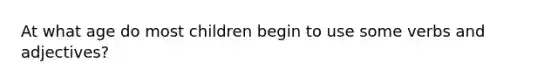 At what age do most children begin to use some verbs and adjectives?