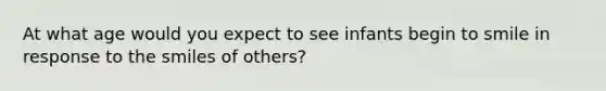 At what age would you expect to see infants begin to smile in response to the smiles of others?