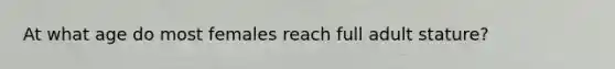 At what age do most females reach full adult stature?