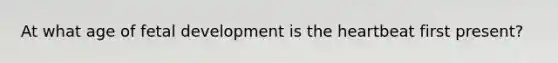 At what age of fetal development is the heartbeat first present?