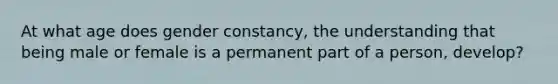 At what age does gender constancy, the understanding that being male or female is a permanent part of a person, develop?