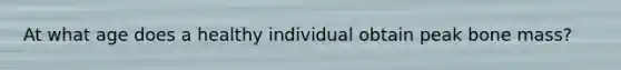 At what age does a healthy individual obtain peak bone mass?